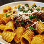 Close-up of a bowl of easy spring pasta dishes with a rich sauce, parmesan, and parsley.