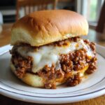 A delicious French Onion Beef Sloppy Joes sandwich with melted cheese on a bun, ready to eat.