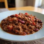 A hearty plate of ground beef recipe with kidney beans and diced tomatoes, ready to eat.