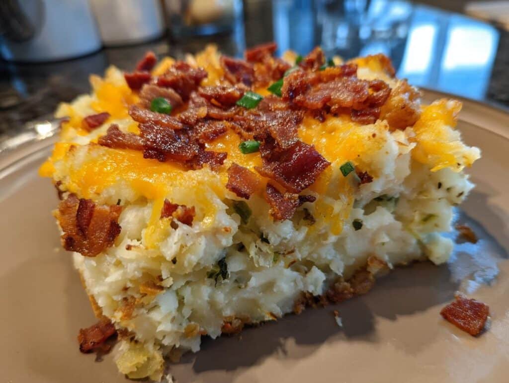 Close-up of potato cake, one of many delicious Irish appetizers, topped with cheese, bacon, and chives.