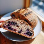 A slice of homemade lemon blueberry sourdough bread showing the texture and blueberries.