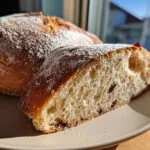 A slice of lemon blueberry sourdough bread on a plate, showcasing its texture and blueberries.