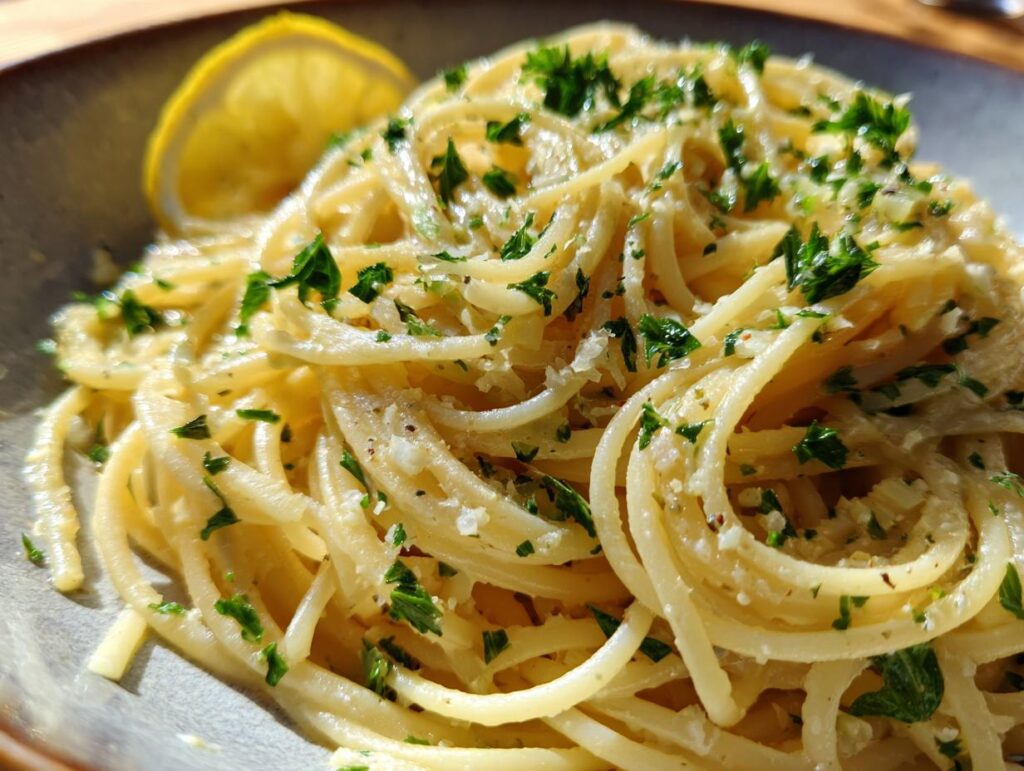 Close-up of Lemon Capellini Salad with lemon wedge and fresh parsley, ready to serve.