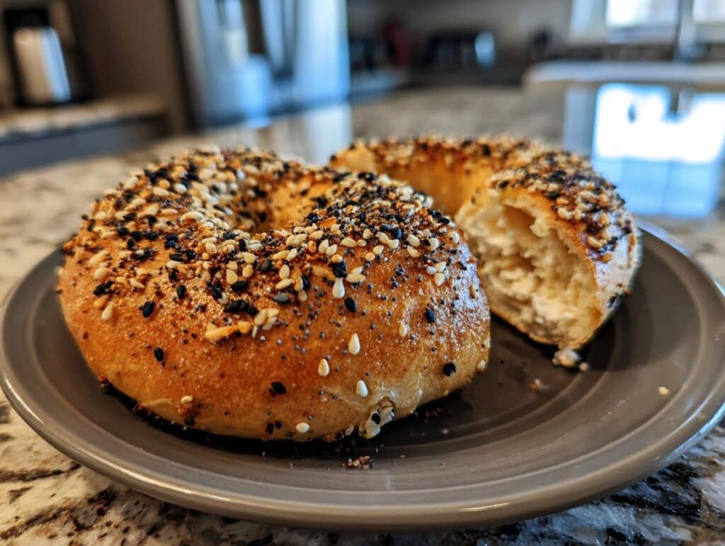 Two protein bagels recipe cottage cheese on a plate, one cut open to show the inside.