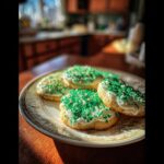 A plate of festive St Patrick’s Day cookies, iced and covered in green sprinkles.