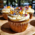 Three wildflower cupcakes with white frosting and edible flower decorations. Delicious wildflower cupcakes.