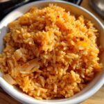 Close-up of a bowl filled with flavorful Mexican rice, featuring visible grains and seasonings.