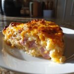 A slice of easy scalloped potatoes and ham recipe, showcasing layers of potatoes, ham, and a cheesy topping.