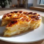 A slice of easy scalloped potatoes recipe with milk, showcasing the creamy layers and golden-brown top.