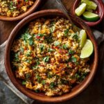 Overhead shot of a Mexican rice bowls chicken in a wooden bowl, garnished with cilantro and lime.