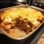 Close-up of a freshly baked Mexican rice chicken bake with melted cheese on top.