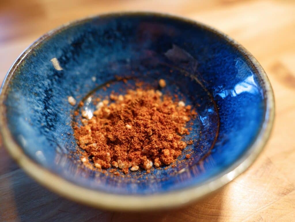 Close-up of a spice mix in a blue bowl, essential for restaurant mexican rice recipe authentic flavor.