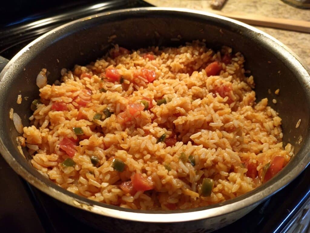 A pan of rice with diced tomatoes and green peppers. Not related to cottage cheese blueberry protein bites.