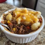Close-up of Shepherd's Pie with ground meat, vegetables, and mashed potato topping with melted cheese.