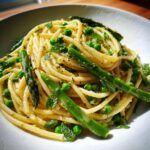 A vibrant spring cold pasta salad featuring pasta, asparagus, peas, and mint.