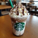 A Starbucks Vanilla Bean Frappuccino with whipped cream, chocolate drizzle, and a green straw.